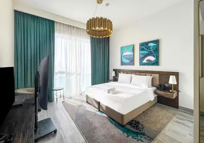 a bedroom with a large bed and a chandelier at Livbnb - 1B Palm Jumeirah and Sea View at Avani in Dubai