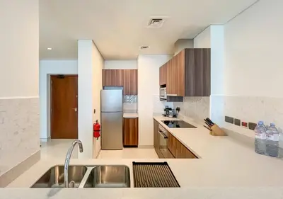 a kitchen with a sink and a refrigerator at Livbnb - 1B Palm Jumeirah and Sea View at Avani in Dubai