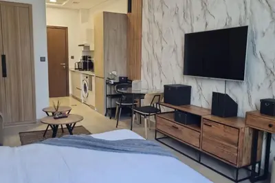 a hotel room with a bed and a flat screen tv at Comfy JVC Studio Pantheon Comfort & Style by Vibel in Dubai