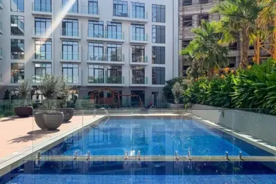 a swimming pool in front of a building at Comfy JVC Studio Pantheon Comfort & Style by Vibel in Dubai