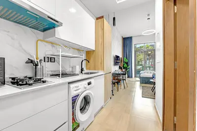 a kitchen with a washer and dryer in a room at Comfy JVC Studio Pantheon Comfort & Style by Vibel in Dubai