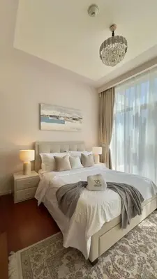 a bedroom with a large white bed and a chandelier at Guest Favorite - Modern 3BR High Views Prime Location at Downtown in Dubai