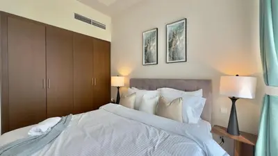 a bedroom with a large white bed with two lamps at Guest Favorite - Modern 3BR High Views Prime Location at Downtown in Dubai