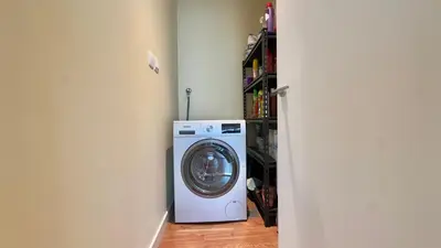 a washing machine in a room next to a shelf at Guest Favorite - Modern 3BR High Views Prime Location at Downtown in Dubai