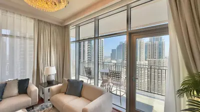 a living room with two chairs and a large window at Guest Favorite - Modern 3BR High Views Prime Location at Downtown in Dubai