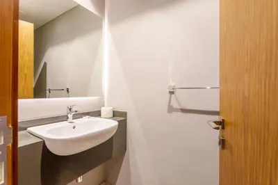 a white bathroom with a sink and a mirror at Stunning Marina Waterfront 2 Bed Escape in Dubai