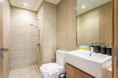 a bathroom with a sink and a toilet and a mirror at Trendy Azizi Riviera 1-Bed with Balcony Views in Dubai