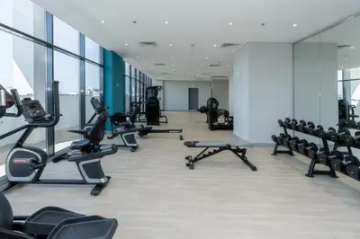 a gym with several treadmills and cardio machines at Trendy Azizi Riviera 1-Bed with Balcony Views in Dubai