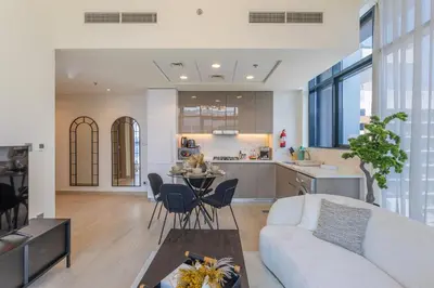 a living room and kitchen with a couch and a table at Trendy Azizi Riviera 1-Bed with Balcony Views in Dubai