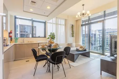 a kitchen and living room with a table and chairs at Trendy Azizi Riviera 1-Bed with Balcony Views in Dubai