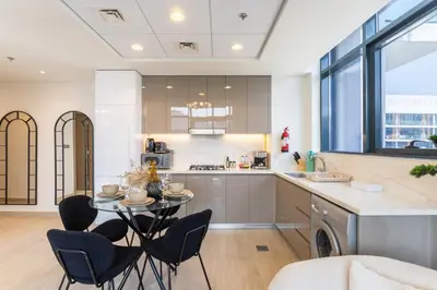 a kitchen with a table and chairs in a room at Trendy Azizi Riviera 1-Bed with Balcony Views in Dubai