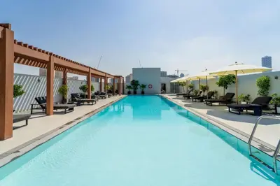 a swimming pool with chairs and umbrellas on a building at Art of Modern Illumination in Dubai