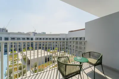 a balcony with chairs and a table and a building at Art of Modern Illumination in Dubai