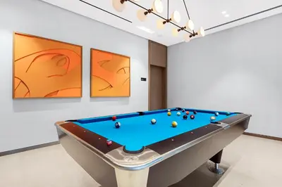 a pool table in a room with paintings at FIRST CLASS 1BR Charming City View in Dubai