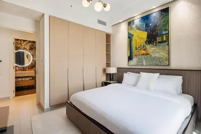 a bedroom with a bed and a painting on the wall at Waterfront Apartment at Dubai Creek Harbour - By DuStay in Dubai