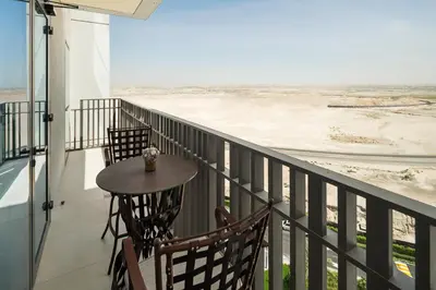 a balcony with a table and chairs and the ocean at Luxurious Apartment, Dubai Creek Harbour - By Dustay in Dubai