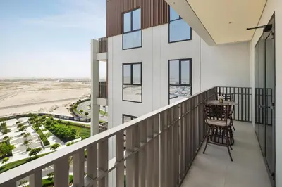a balcony with a table and chairs looking out at the desert at Luxurious Apartment, Dubai Creek Harbour - By Dustay in Dubai