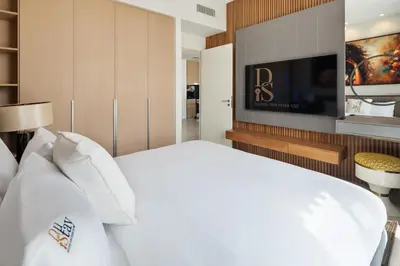 a bedroom with a white bed and a tv at Elegant Apartment for Relaxation, Creek Harbour - By DuStay in Dubai