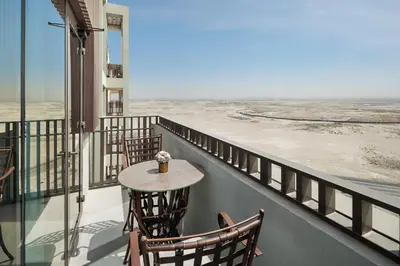 a balcony with a table and chairs looking out at the ocean at Elegant Apartment for Relaxation, Creek Harbour - By DuStay in Dubai