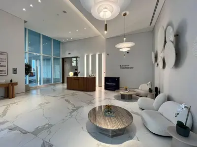 a lobby with a table and chairs in a building at FIRST CLASS 1BR Stunning Marina & Palm View in Dubai