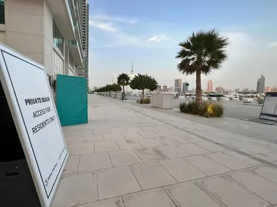 a sign on a sidewalk next to a building at FIRST CLASS 1BR Stunning Marina & Palm View in Dubai