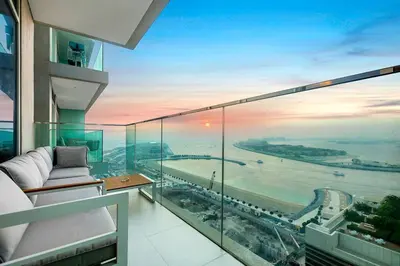 a room with a balcony with a view of the ocean at FIRST CLASS 1BR Stunning Marina & Palm View in Dubai