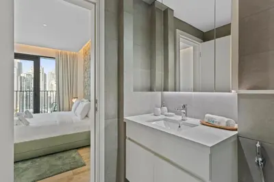 a bathroom with a sink and a bed and a window at Stunning 1 bedroom Apartment w Burj Khalifa View in Dubai