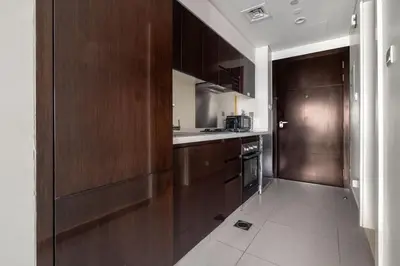 a kitchen with dark wood cabinets and a stove at GuestReady - Luxurious studio in Business Bay in Dubai