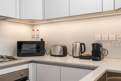 a kitchen counter with a microwave and appliances on it at New Charming Studio in JVC in Dubai