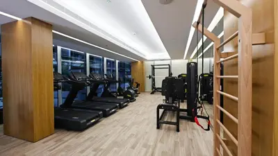 a gym with treadmills and ellipticals in a room at New Charming Studio in JVC in Dubai