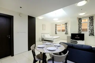 a living room with a table and a couch at Livbnb-Spacious JVC Studio, Near Dining and Shops in Dubai