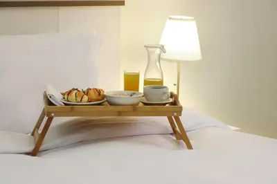a tray with food and drinks on a bed at Livbnb-Spacious JVC Studio, Near Dining and Shops in Dubai