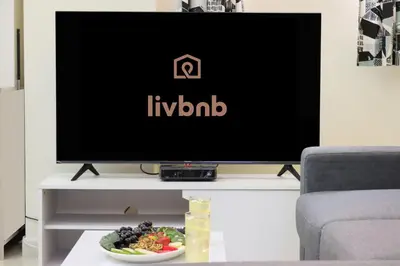 a television on a table with a bowl of food at Livbnb-Spacious JVC Studio, Near Dining and Shops in Dubai