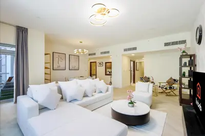 a living room with white couches and a table at Livbnb Suites - Burj Khalifa View 2BR spacious apt in Dubai