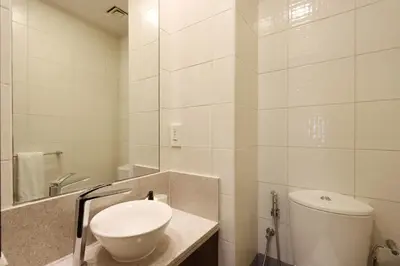 a white bathroom with a toilet and a sink at Livbnb Suites - Burj Khalifa View 2BR spacious apt in Dubai