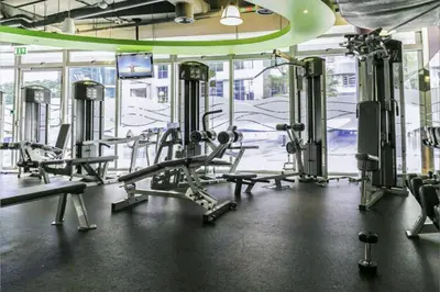a gym with several tread machines and a tv at Livbnb Suites - Burj Khalifa View 2BR spacious apt in Dubai