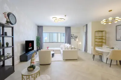 a living room with a white couch and a table at Livbnb Suites - Burj Khalifa View 2BR spacious apt in Dubai