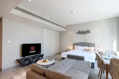 a bedroom with a bed and a couch and a tv at Livbnb -Glam Studio in Marina Next to Marina Walk in Dubai