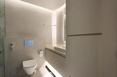 a white bathroom with a toilet and a sink at Livbnb -Glam Studio in Marina Next to Marina Walk in Dubai