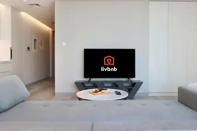 a living room with a tv and a couch at Livbnb -Glam Studio in Marina Next to Marina Walk in Dubai