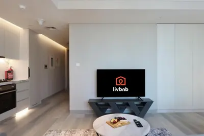 a living room with a tv and a table at Livbnb -Glam Studio in Marina Next to Marina Walk in Dubai