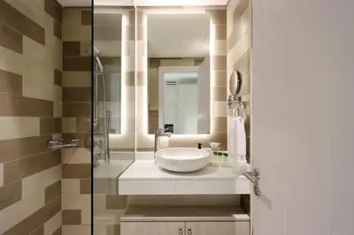 a bathroom with a sink and a glass shower at Exquisite Studio near Nakheel Mall by Livbnb in Dubai
