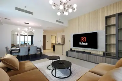 a living room with a couch and a tv at Livbnb - 3BR Plus 1 with Burj and Fountain Views in Dubai