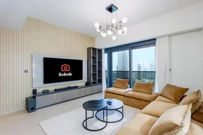a living room with a couch and a tv at Livbnb - 3BR Plus 1 with Burj and Fountain Views in Dubai