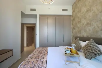 a bedroom with a bed with a tray of food on it at Livbnb - 3BR Plus 1 with Burj and Fountain Views in Dubai