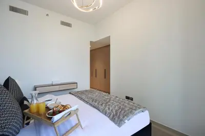 a bedroom with a bed and a table with food on it at Livbnb - 3BR Plus 1 with Burj and Fountain Views in Dubai