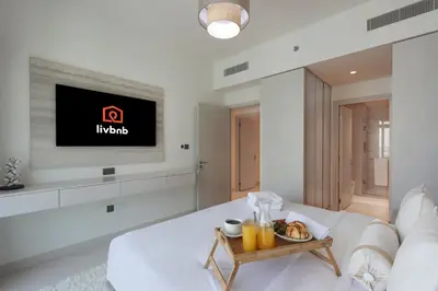 a living room with a white couch and a tv at Livbnb-Beachfront 3BR with Marina Harbour Panorama in Dubai