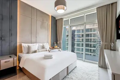 a bedroom with a large white bed and a large window at Livbnb-Beachfront 3BR with Marina Harbour Panorama in Dubai