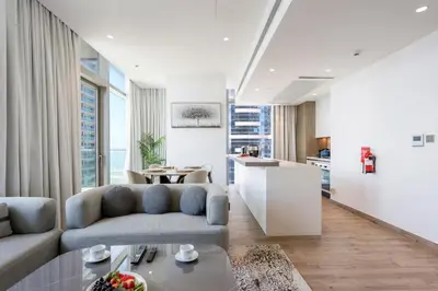 a living room with a couch and a table at 2BR Sunset View Suite -Jumeirah Living Marina Gate in Dubai