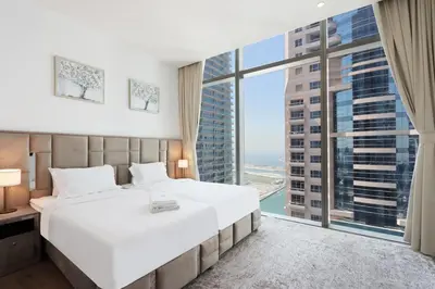 a bedroom with a large white bed and a large window at 2BR Sunset View Suite -Jumeirah Living Marina Gate in Dubai